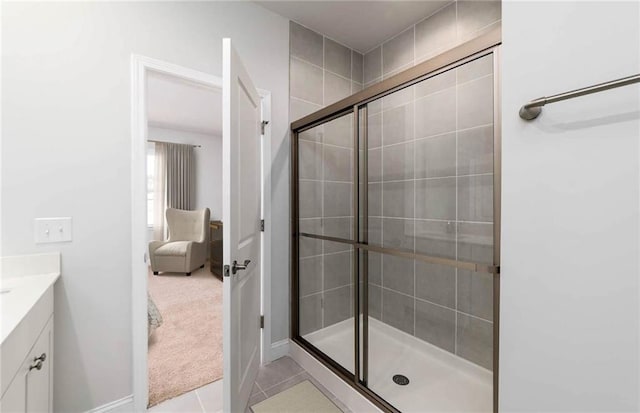 bathroom featuring tile patterned flooring, an enclosed shower, and vanity