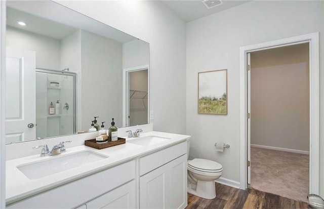 bathroom featuring vanity, hardwood / wood-style flooring, toilet, and walk in shower