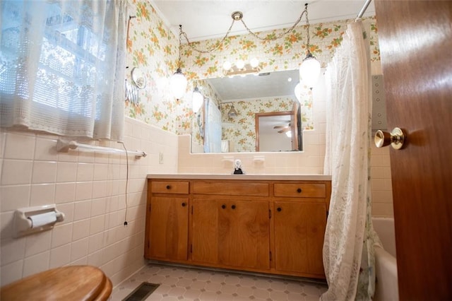 full bathroom featuring tile patterned floors, toilet, tile walls, vanity, and shower / bath combination with curtain