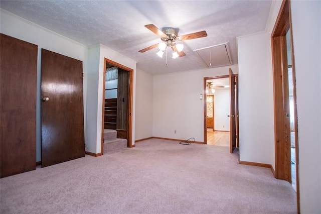 unfurnished bedroom featuring a textured ceiling, light colored carpet, a closet, and ceiling fan