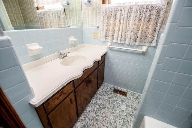 bathroom with vanity and tile walls