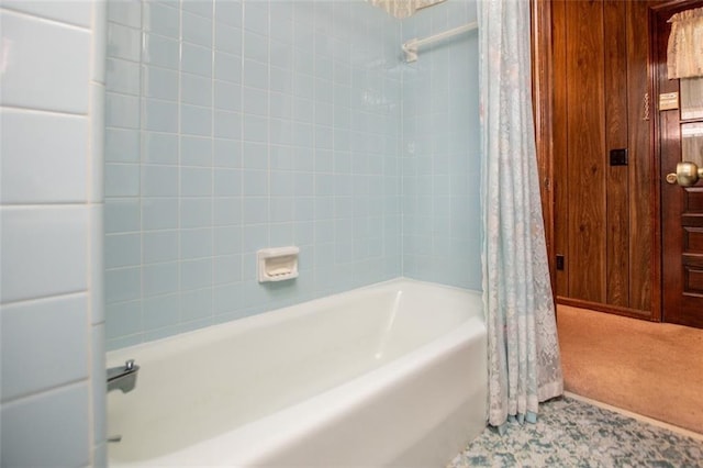 bathroom with shower / bath combo and wood walls