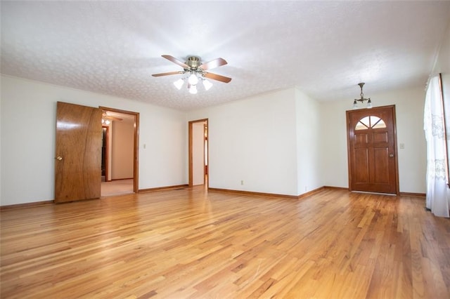 entryway with ceiling fan, a textured ceiling, and light wood-type flooring