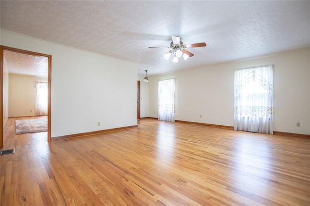 spare room with ceiling fan, a textured ceiling, and light hardwood / wood-style flooring