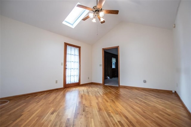 unfurnished room featuring lofted ceiling with skylight, ceiling fan, and light hardwood / wood-style floors