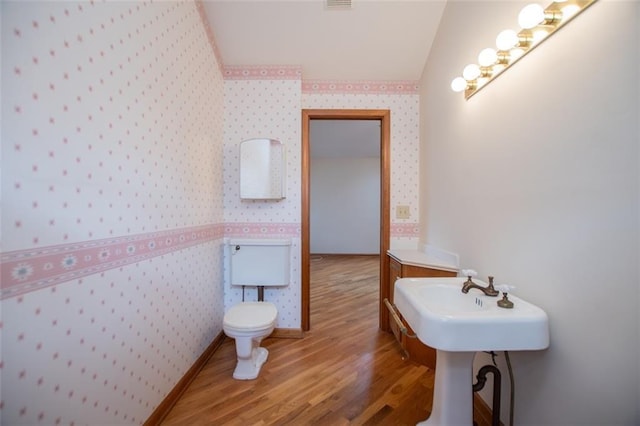 bathroom featuring hardwood / wood-style flooring and toilet