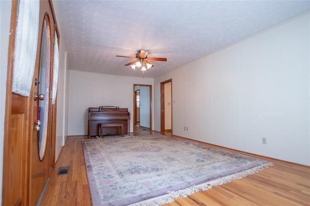 interior space featuring ceiling fan, hardwood / wood-style floors, and a textured ceiling