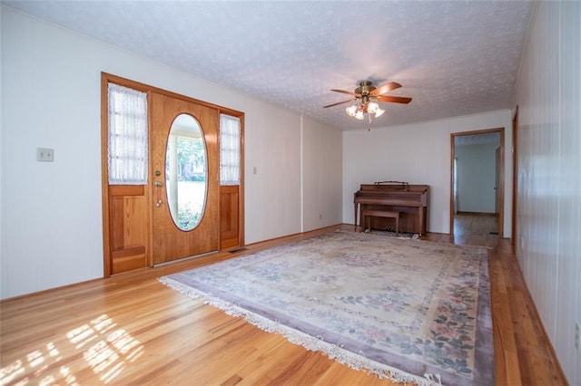 entryway featuring hardwood / wood-style flooring, ceiling fan, and a textured ceiling