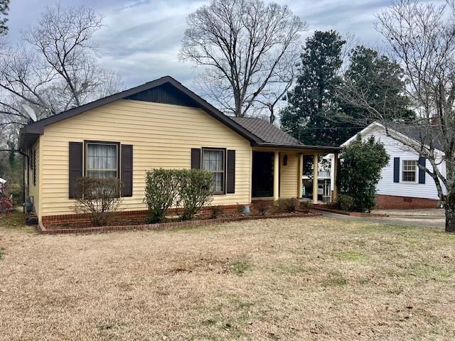 single story home featuring a front lawn