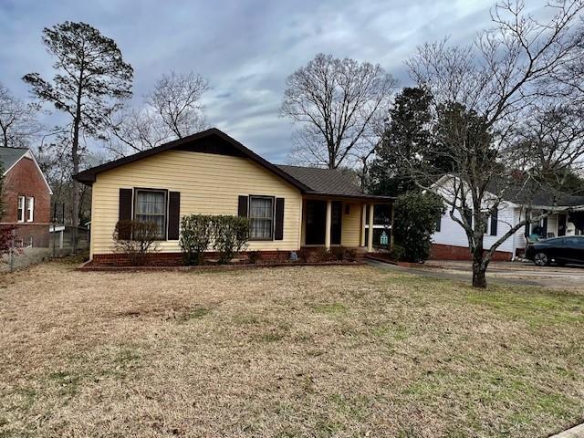 single story home featuring a front lawn