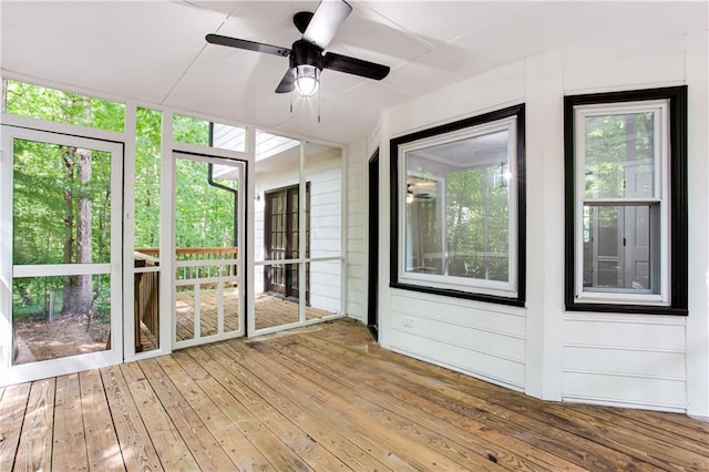 unfurnished sunroom featuring a healthy amount of sunlight and ceiling fan