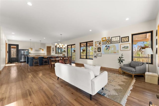 living room with an inviting chandelier and hardwood / wood-style flooring