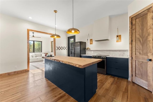 kitchen with black fridge, decorative light fixtures, stainless steel electric stove, and hardwood / wood-style flooring