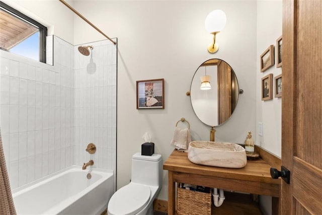 full bathroom featuring toilet, tiled shower / bath combo, and sink