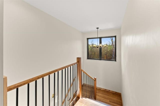 staircase featuring hardwood / wood-style floors and a chandelier