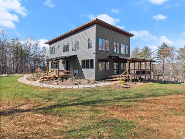 rear view of house with a yard and a wooden deck