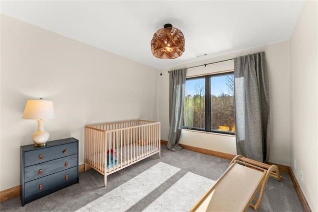 bedroom featuring a crib and carpet flooring