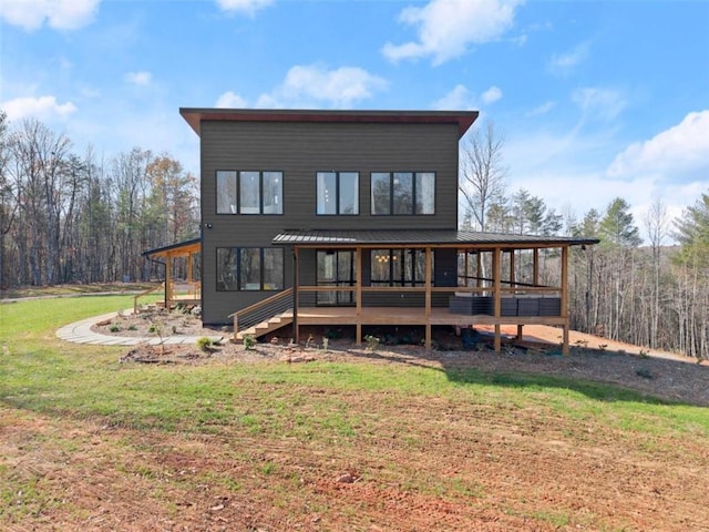 rear view of property with a lawn and a deck