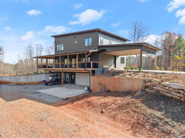 back of property featuring a garage and central AC