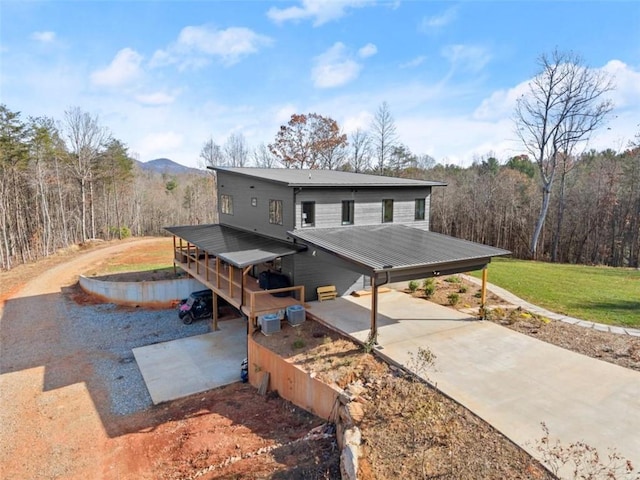 exterior space with a mountain view, a lawn, and a carport