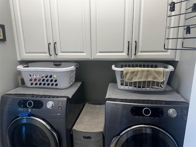 clothes washing area with cabinets and washing machine and dryer