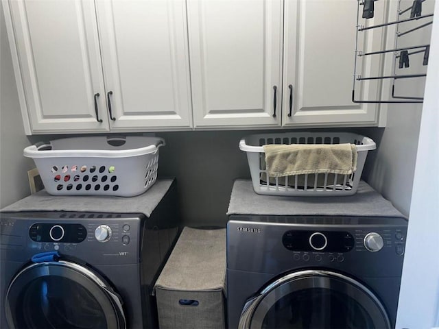 washroom featuring washer and dryer and cabinets