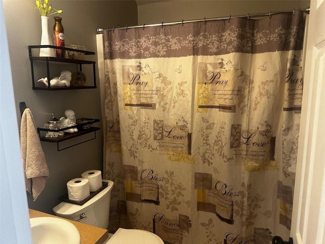 bathroom with sink, toilet, and curtained shower