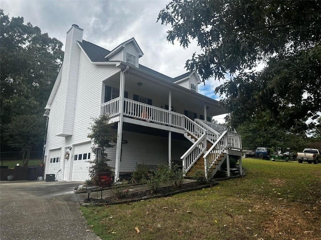 view of home's exterior with a garage, a porch, and a lawn