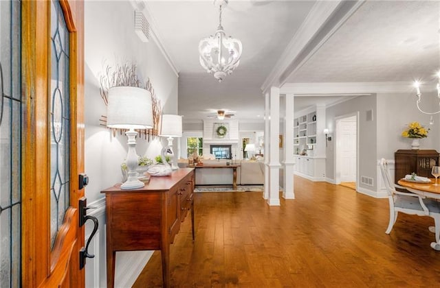 foyer entrance featuring a chandelier, wood-type flooring, and crown molding