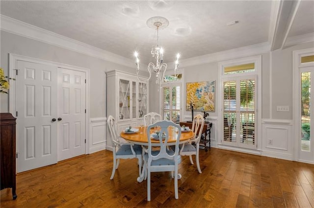 dining room featuring wood-type flooring, an inviting chandelier, and crown molding