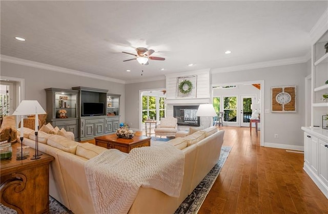 living room featuring ceiling fan, ornamental molding, a wealth of natural light, and french doors