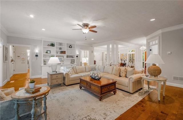 living room with light hardwood / wood-style floors, ceiling fan, and crown molding