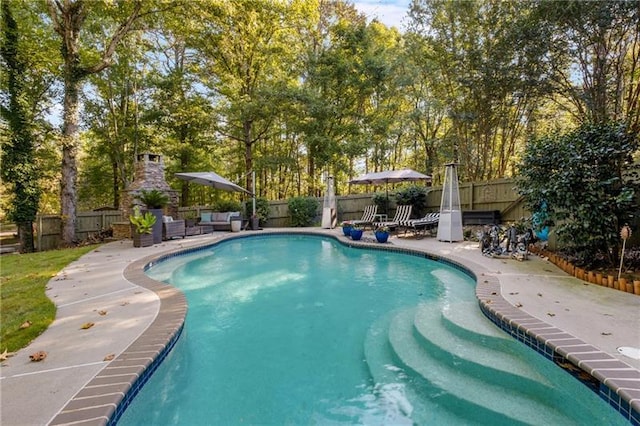 view of swimming pool featuring a patio area and an outdoor fireplace