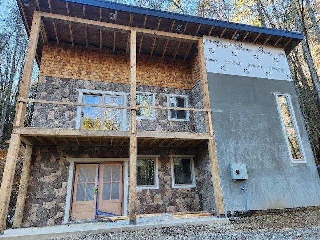 exterior space with a balcony and stone siding