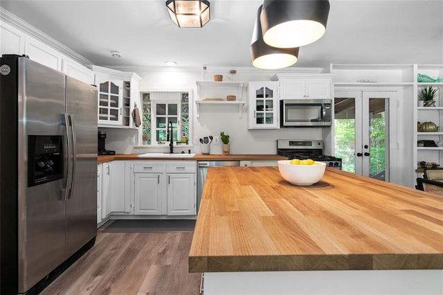 kitchen with white cabinets, appliances with stainless steel finishes, butcher block counters, and sink