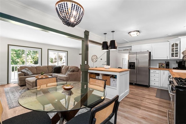 dining space featuring a notable chandelier, light wood-type flooring, and ornamental molding