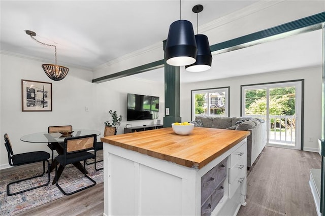 kitchen featuring an inviting chandelier, white cabinets, pendant lighting, and wood counters