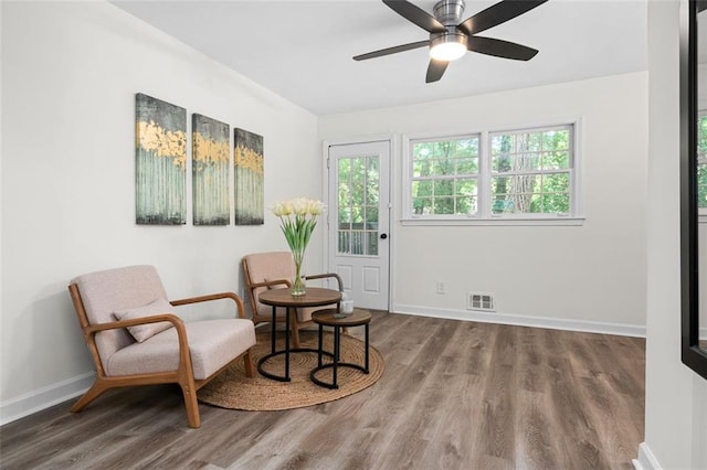 sitting room with hardwood / wood-style floors and ceiling fan