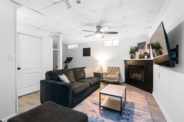 living room featuring hardwood / wood-style floors, a paneled ceiling, and ceiling fan