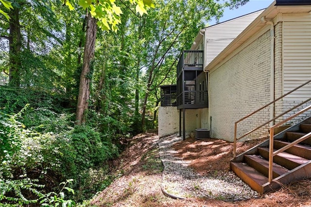 view of yard featuring a balcony and central air condition unit