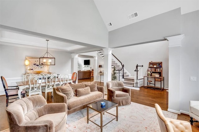 1473 Cardova Pointe, Dunwoody, GA 30338 - living room with decorative columns, wood finished floors, stairway, a chandelier, and high vaulted ceiling