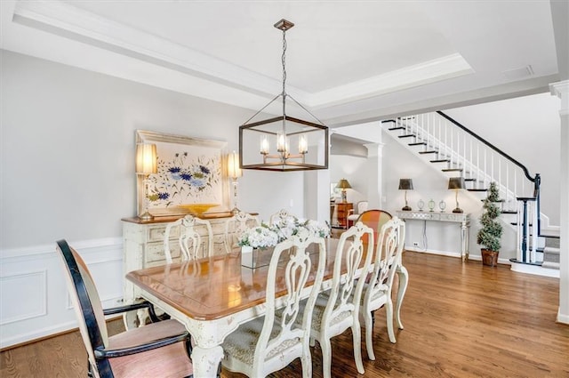 1473 Cardova Pointe, Dunwoody, GA 30338 - dining space featuring stairway, a chandelier, a raised ceiling, wood finished floors, and wainscoting