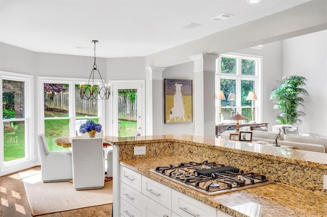 1473 Cardova Pointe, Dunwoody, GA 30338 - kitchen with stovetop with downdraft, light stone countertops, white cabinets, and light wood-style flooring