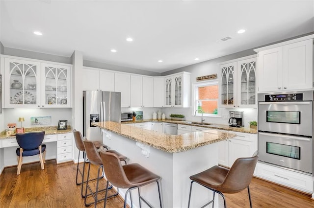 1473 Cardova Pointe, Dunwoody, GA 30338 - kitchen with appliances with stainless steel finishes, built in study area, a kitchen island, a kitchen bar, and recessed lighting