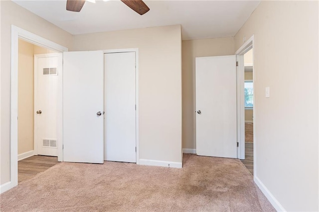 unfurnished bedroom with ceiling fan, a closet, and light colored carpet