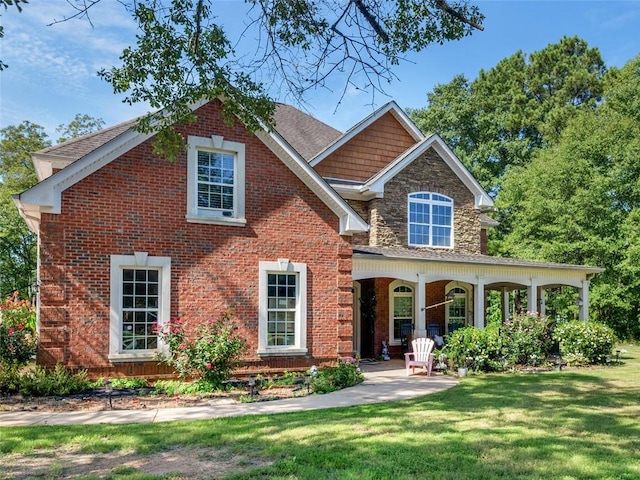 view of front of property with a porch and a front lawn