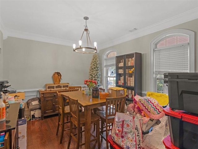 dining room with crown molding, dark wood-type flooring, and a chandelier