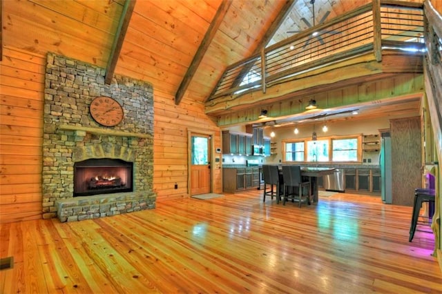 179 Huckleberry Ln, Ellijay, GA 30536 - living area featuring light wood-type flooring, high vaulted ceiling, beamed ceiling, a fireplace, and wood walls