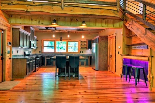 179 Huckleberry Ln, Ellijay, GA 30536 - kitchen with stainless steel appliances, light wood-style flooring, dark countertops, and hanging light fixtures