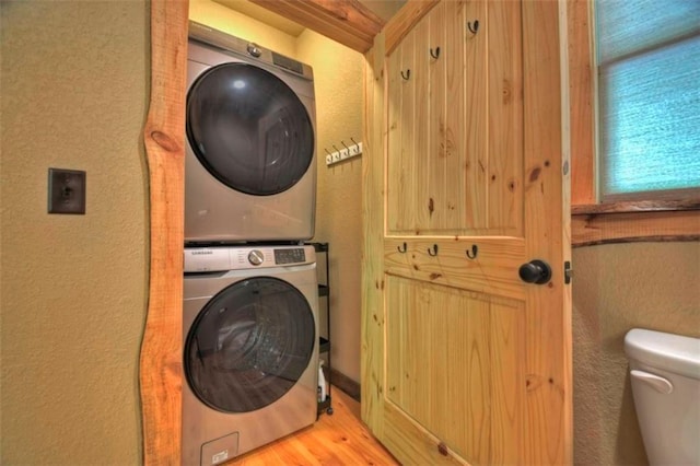179 Huckleberry Ln, Ellijay, GA 30536 - laundry area featuring stacked washer and clothes dryer, a textured wall, and wood finished floors